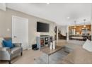 Living area with light wood-style flooring, stairway, and recessed lighting