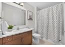 Full bathroom with light tile patterned floors, vanity, and shower / bath combo with shower curtain
