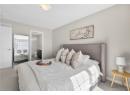 Carpeted bedroom featuring ensuite bath and baseboards