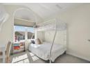Carpeted bedroom with baseboards and vaulted ceiling