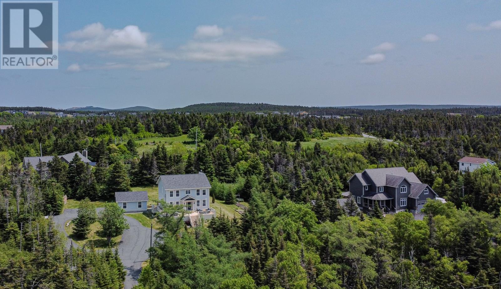 This beautiful home is nestled on ultra private tree lined 1.5-acres tucked away on a quiet side road in Portugal Cove–St. Philips. The main floor features hardwood, crown mouldings, Victorian headers, and elegant tray ceilings. The gourmet kitchen is a dream for any home chef, boasting stone countertops, tiled backsplash, double wall ovens, gas cooktop, and a generous island (seats 4) Step outside from the kitchen onto the back patio, where you can enjoy morning sun and peaceful views of the private, tree-lined yard. Enjoy hosting in the formal dining room or quiet time in front of the fireplace in the living room. The adjoining flex room can be a playroom,  office, or can be seamlessly opened up to expand the main living area. Upstairs, there is a 4 piece guest bath, 3 bedrooms including a spacious primary suite with a walk-in closet, a ensuite (soaker tub & tiled shower)  and a bonus room ideal as a nursery, office or walk-in closet.  The basement offers a large rec room (electric fireplace, custom built-ins) ideal for movie nights. There’s also a play area with space for a future wet bar, bedroom, 3 piece bath and laundry room with custom cabinetry. A spacious storage/mechanical area offers easy access to the efficient five-zone hot water heating system. Outside, a wraparound driveway leads to a 24x24 detached garage (wired and paneled) and garden sheds and kitchen gardens. The front veranda is the perfect spot to unwind and take in the quiet surroundings and evening sun. Additional updates include three mini splits located in the basement rec room, main floor living room, and primary ensuite—offering year-round comfort and efficiency. Located in a sought-after school catchment, with busing to Beachy Cove Elementary, Brookside Intermediate, and the upcoming new high school, this home offers the rare combination of country living, modern convenience, and total privacy. This is the peaceful lifestyle you’ve been waiting for—move-in ready and one of a kind. (id:48254)