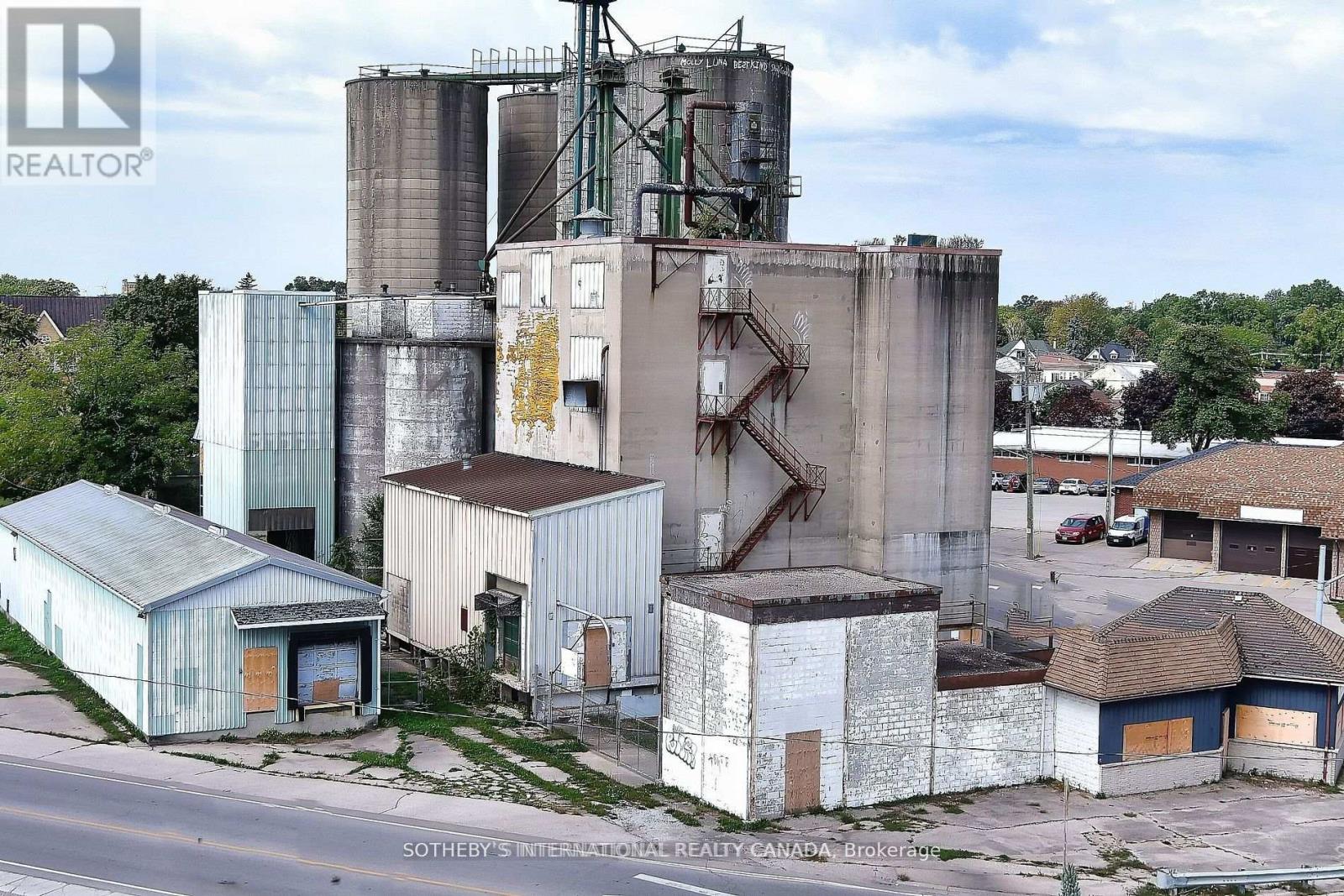 A unique opportunity in Downtown Strathroy, this 0.59-acre property with approximately 12,000 sq. ft. of production space offers excellent potential as a flour mill, grain mill, or brewery. The site includes a mill with a capacity of roughly 100 tons of flour per day, four silos (1,350 tons each), six transitional silos, and two large storage/warehouse buildings leased from CN Railway. The sale includes the real estate and existing flour mill equipment, with brewery equipment available for purchase separately, allowing buyers the flexibility to revive milling operations, expand into brewing or distilling, or adapt the facility to suit their business vision. (id:48254)