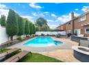 View of swimming pool featuring a patio, a fenced backyard, a fire pit, and exterior kitchen