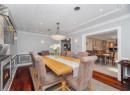 Dining space featuring ornamental molding, dark wood-style flooring, recessed lighting, wainscoting, and a decorative wall