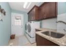 Laundry room with a textured ceiling, light tile patterned flooring, washing machine and dryer, and cabinet space