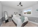 Bedroom with light carpet, a textured ceiling, and ceiling fan