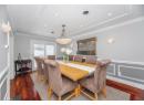 Dining space with ornamental molding, recessed lighting, dark wood-style flooring, a decorative wall, and a wainscoted wall