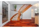Staircase with wood finished floors and crown molding