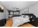 Bedroom with light wood finished floors, a textured ceiling, and ceiling fan