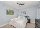 Bedroom featuring light carpet, a textured ceiling, and ceiling fan