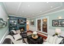 Living area with crown molding, recessed lighting, wood finished floors, a lit fireplace, and wainscoting