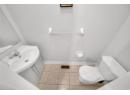 Half bathroom with tile patterned floors and vanity