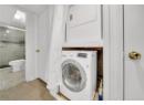 Laundry area featuring stacked washer and clothes dryer and tile patterned flooring
