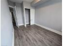 Unfurnished bedroom featuring dark wood-style floors and a closet