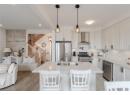 Kitchen featuring stainless steel appliances, light stone countertops, a breakfast bar, pendant lighting, and recessed lighting