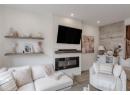 Living area with a glass covered fireplace, wood finished floors, recessed lighting, and wood walls
