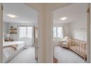 Bedroom featuring light colored carpet and a crib