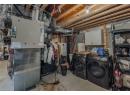 Unfinished basement with washing machine and dryer and heating unit