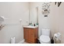 Half bathroom with vanity and light tile patterned flooring
