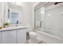 Full bath featuring combined bath / shower with glass door, light tile patterned flooring, and vanity