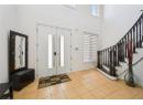 Foyer featuring light tile patterned floors, stairway, and a high ceiling