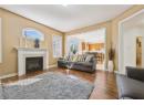 Living room featuring healthy amount of natural light, wood finished floors, a premium fireplace, and a textured ceiling