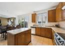 Kitchen with brown cabinetry, appliances with stainless steel finishes, decorative backsplash, light countertops, and recessed lighting