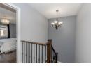 Staircase featuring a chandelier, wood finished floors, and a textured ceiling