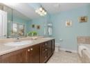 Bathroom with double vanity, a garden tub, and light tile patterned flooring