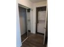 Laundry room featuring stacked washing machine and dryer and dark wood finished floors