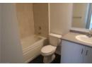 Bathroom featuring vanity, washtub / shower combination, and dark tile patterned floors