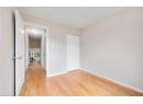 Unfurnished bedroom with light wood finished floors, crown molding, and a closet
