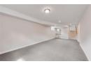 Below grade area with recessed lighting, stairway, a textured ceiling, and carpet floors