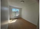 Unfurnished room featuring radiator heating unit and wood finished floors