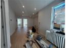 Living area with radiator, light wood-style floors, and recessed lighting
