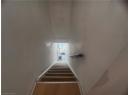 Stairs with wood finished floors and baseboards