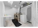 Washroom with washing machine and clothes dryer and light tile patterned floors