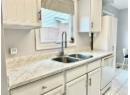 Kitchen with white dishwasher and white cabinets