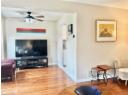 Living area with light wood finished floors and a ceiling fan