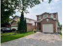 View of front of property with brick siding and a garage