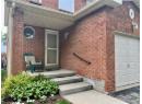 View of exterior entry featuring brick siding and a garage