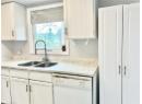 Kitchen featuring white dishwasher and white cabinetry