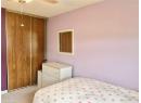 Bedroom with light colored carpet, a closet, and ceiling fan