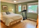 Bedroom with multiple windows and light wood-style flooring