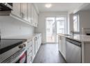 Kitchen with white cabinets, stainless steel appliances, dark wood finished floors, light stone counters, and ventilation hood