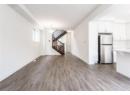 Unfurnished living room with dark wood-style floors and stairway