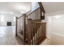 Stairs with a fireplace and wood finished floors