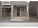 Entrance to property with a porch, stone siding, brick siding, and a garage