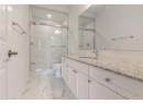 Full bath featuring vanity, a shower stall, and light marble finish flooring