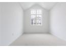 Carpeted empty room with vaulted ceiling and baseboards